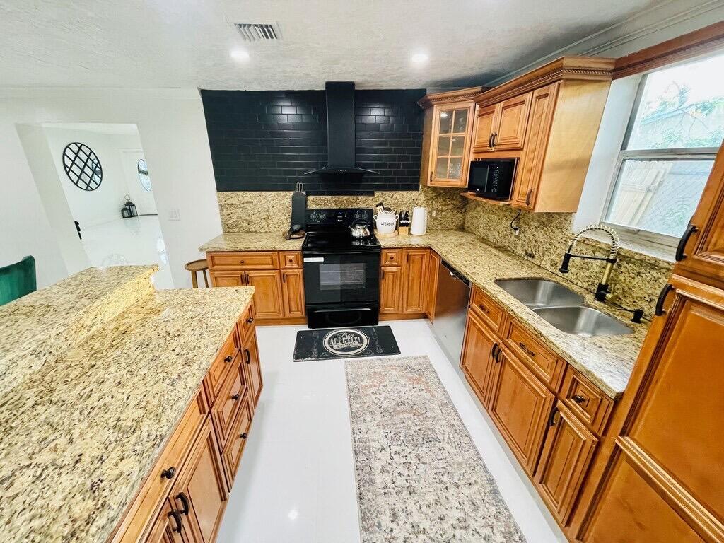 5537 Southwest 6th Street Margate, FL 33068 - Photo 3 of 40 a kitchen with stainless steel appliances granite countertop a sink stove and refrigerator