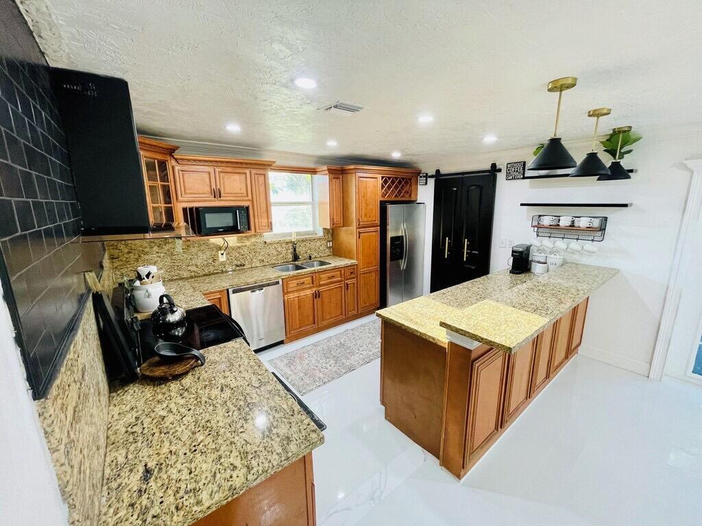 5537 Southwest 6th Street Margate, FL 33068 - Photo 5 of 40 a kitchen with stainless steel appliances granite countertop a sink stove and refrigerator