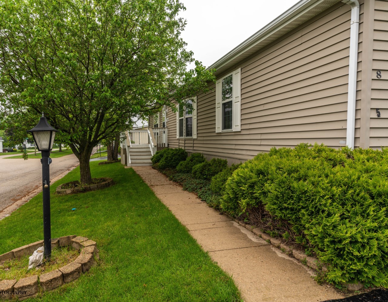 895 Cayuga Trail Marengo, IL 60152 - Photo 2 of 39 a backyard of a house with plants and large tree