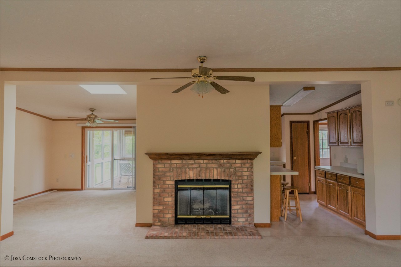 895 Cayuga Trail Marengo, IL 60152 - Photo 9 of 39 a living room with a fireplace furniture a ceiling fan and a rug