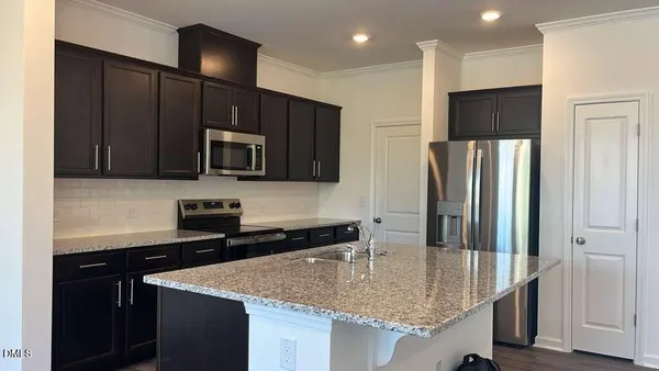 a kitchen with stainless steel appliances granite countertop a sink refrigerator and microwave
