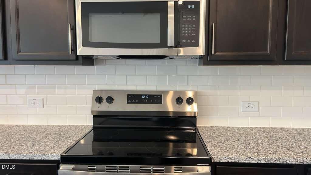 142 Blossom Fld Way Angier, NC 27501 - Photo 31 of 33 a kitchen with granite countertop a stove and a microwave