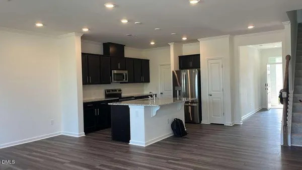 a view of a kitchen with a sink refrigerator and wooden floor