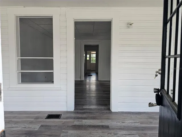 a view of a hallway with wooden floor and staircase
