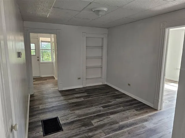 a view of a room has wooden floor and window