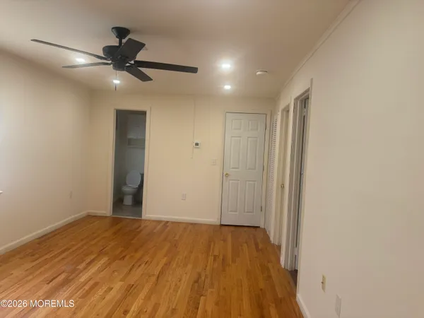 a view of a big room with wooden floor and windows