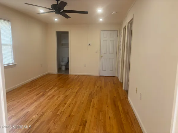 an empty room with wooden floor a ceiling fan and closet