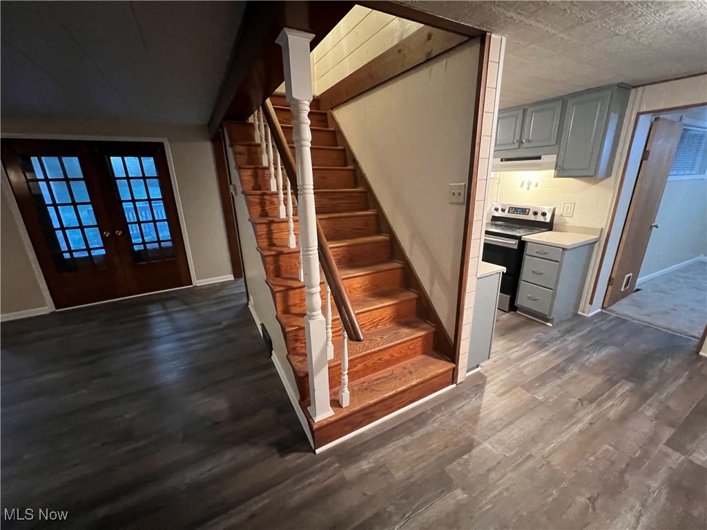280 Holly Road Northwest Dellroy, OH 44620 - Photo 7 of 26 Staircase with french doors, a textured ceiling, and hardwood / wood-style floors
