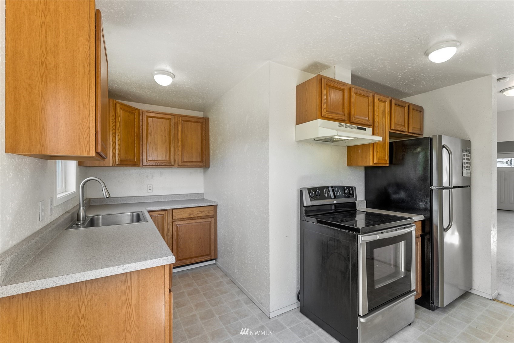 1234 South State Street Tacoma, WA 98405 - Photo 18 of 26 a kitchen with stainless steel appliances granite countertop a sink stove and refrigerator
