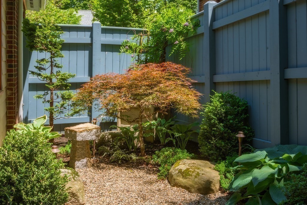 24 Jordan Road Brookline, MA 02446 - Photo 23 of 27 a backyard of a house with plants and large trees