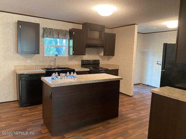 54311 Heron Road Callahan, FL 32011 - Photo 15 of 36 a kitchen with granite countertop a sink and a refrigerator