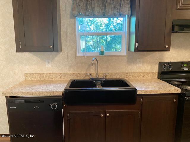 54311 Heron Road Callahan, FL 32011 - Photo 16 of 36 a kitchen with a sink a counter cabinets and a window