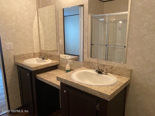 54311 Heron Road Callahan, FL 32011 - Photo 28 of 36 a bathroom with a granite countertop sink and a mirror