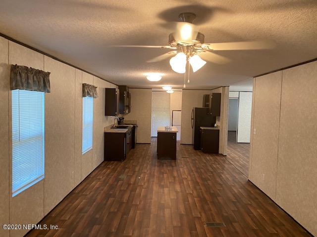 54311 Heron Road Callahan, FL 32011 - Photo 31 of 36 a view of a kitchen with a refrigerator a ceiling fan and wooden floor