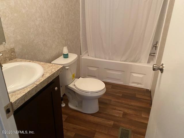 54311 Heron Road Callahan, FL 32011 - Photo 32 of 36 a bathroom with a granite countertop toilet and a sink