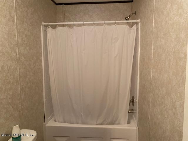 54311 Heron Road Callahan, FL 32011 - Photo 33 of 36 a bathroom with a shower curtain and a toilet