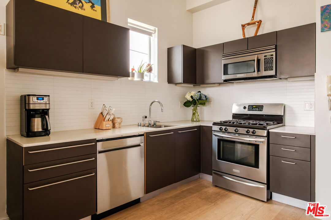 1912 Broadway, Unit 205 Santa Monica, CA 90404 - Photo 9 of 22 a kitchen with stainless steel appliances granite countertop a stove and a microwave