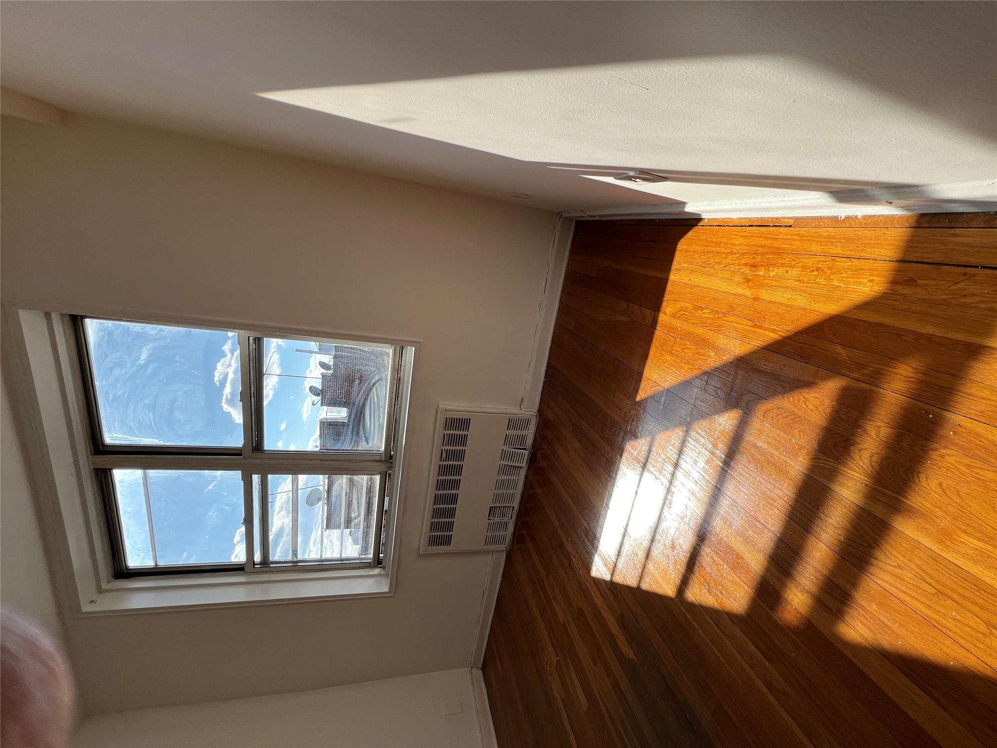 1475 Thieriot Avenue, Unit 5J Bronx, NY 10460 - Photo 2 of 14 a view of an empty room with wooden floor and a window