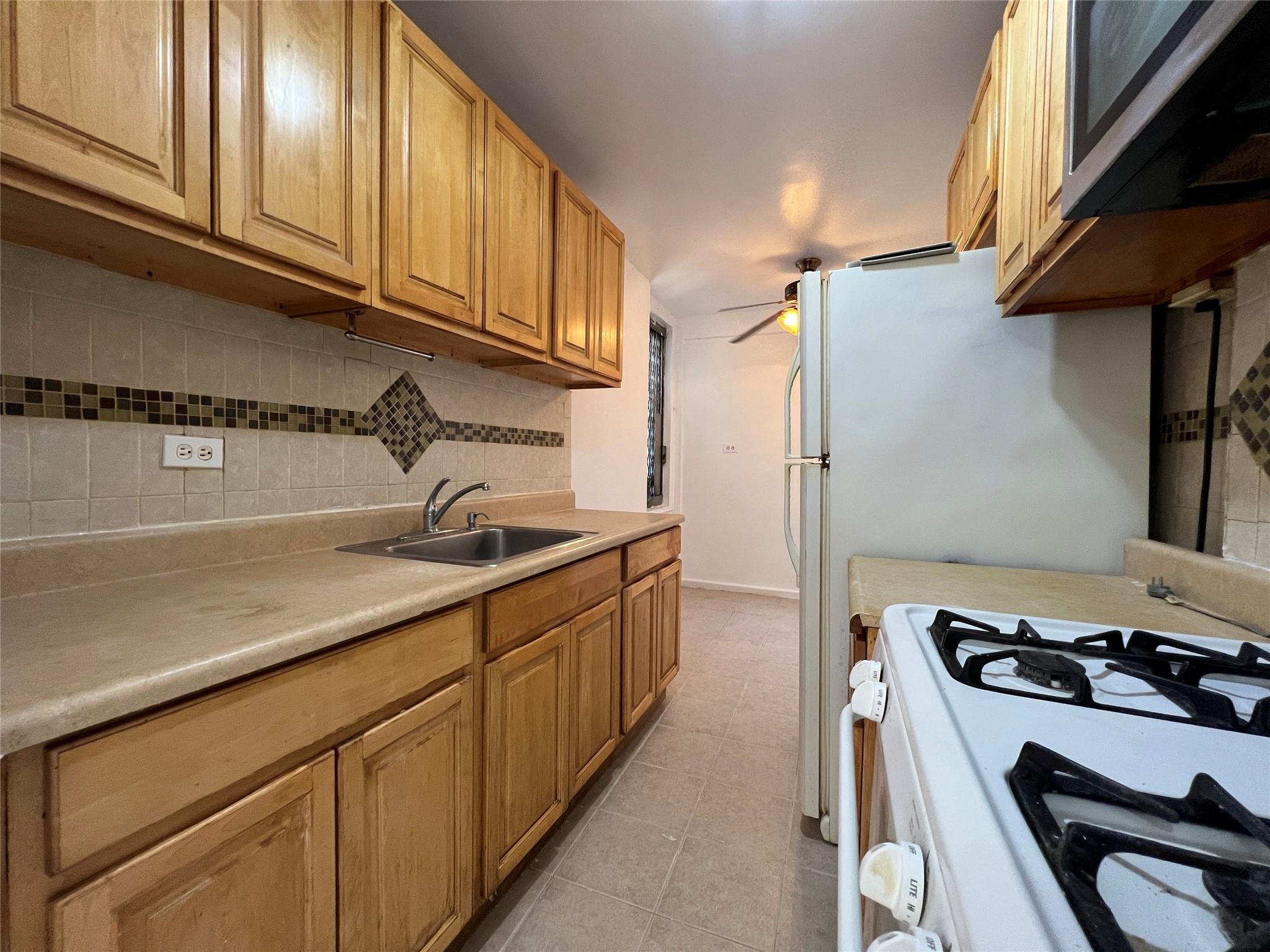 1475 Thieriot Avenue, Unit 5J Bronx, NY 10460 - Photo 5 of 14 a kitchen with stainless steel appliances a sink a stove and cabinets