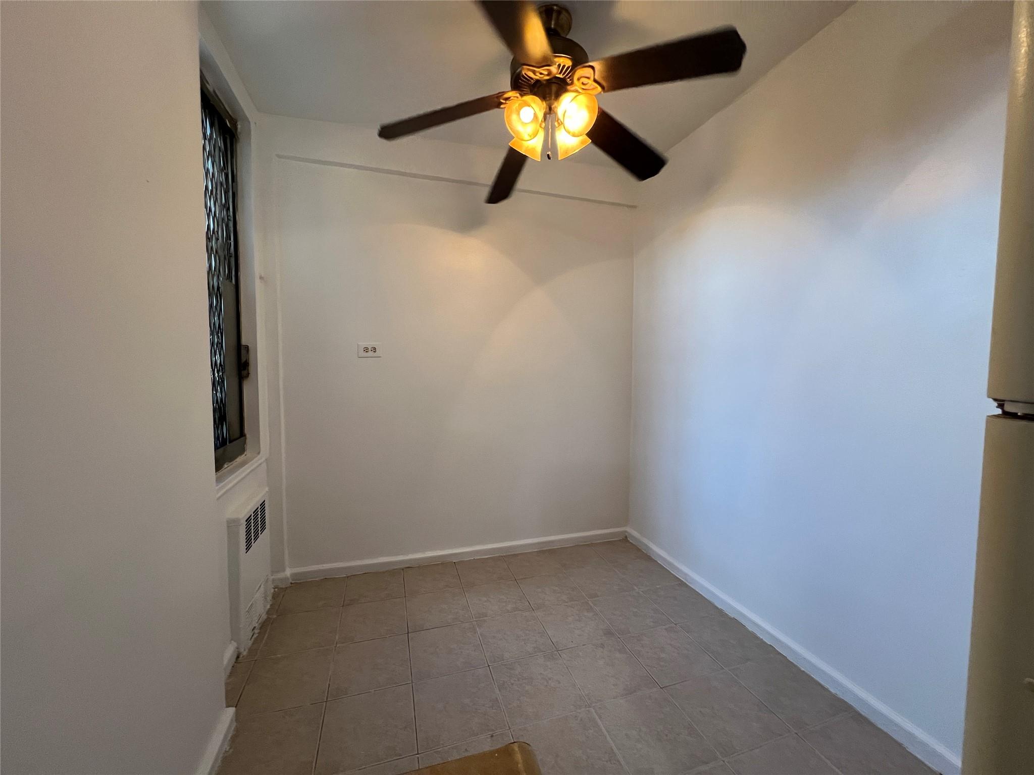 1475 Thieriot Avenue, Unit 5J Bronx, NY 10460 - Photo 7 of 14 an empty room with a window and a fan