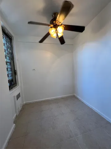 en empty room with window and chandelier fan