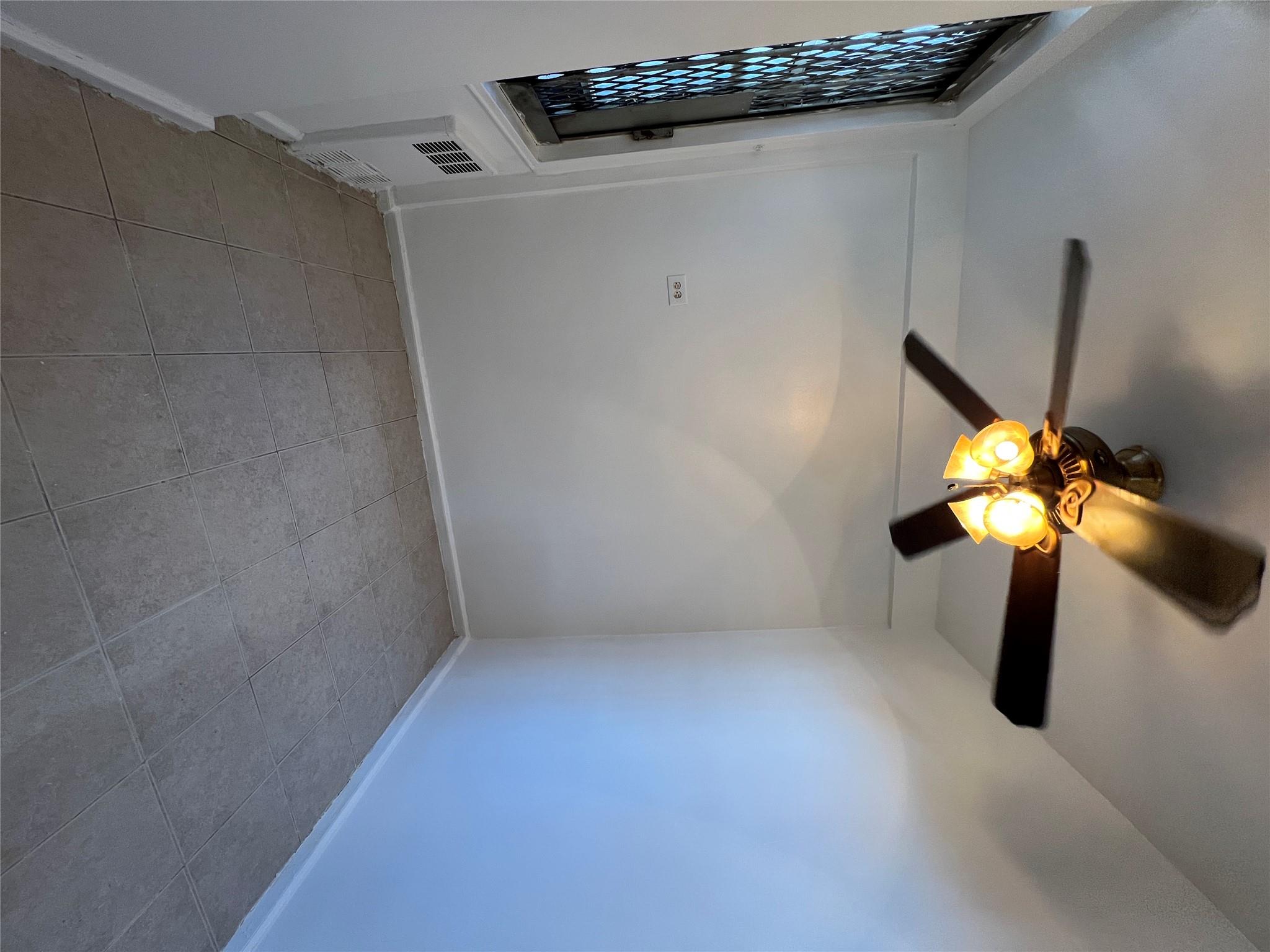 1475 Thieriot Avenue, Unit 5J Bronx, NY 10460 - Photo 8 of 14 en empty room with window and chandelier fan