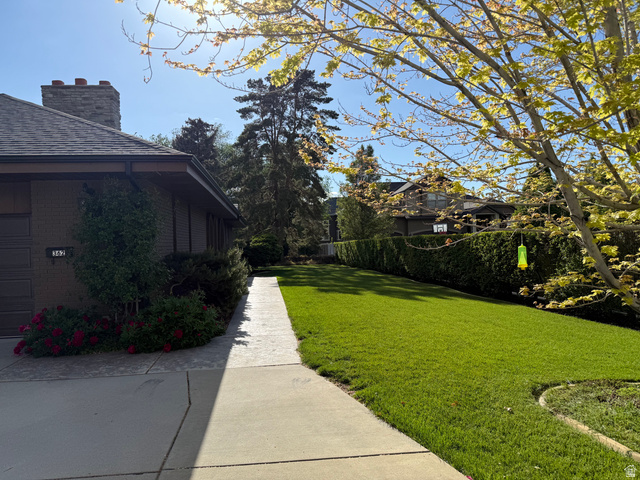 362 East 9150th Street South Sandy, UT 84070 - Photo 17 of 41 Expansive front yard featuring a manicured lawn, established shrubbery, and a mature deciduous tree