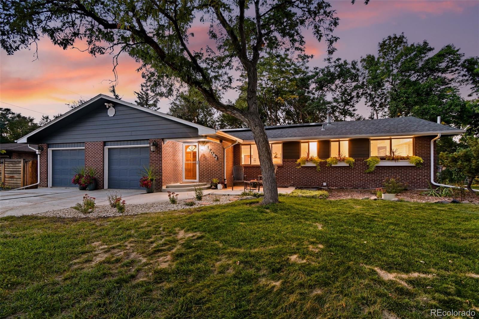 a front view of a house with a garden and trees