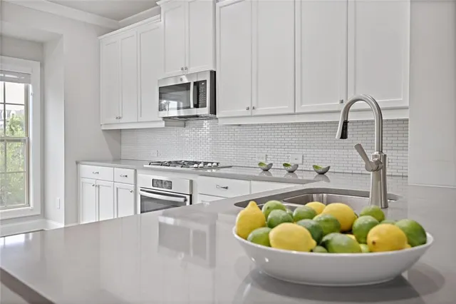 a kitchen with a stove a sink and a white cabinets