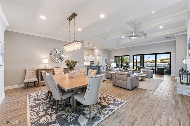 a dining room with wooden floor a chandelier a wooden table and chairs