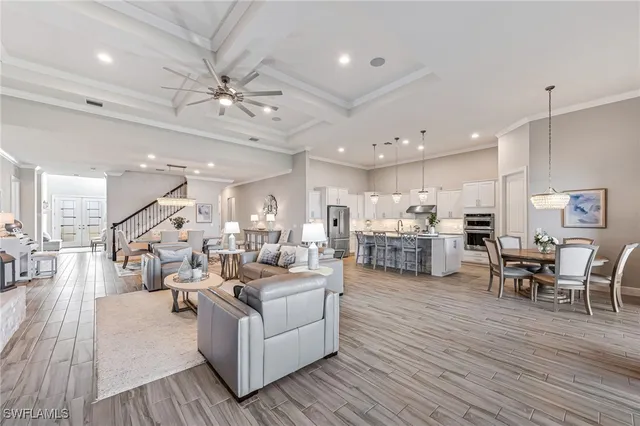 a living room with furniture kitchen view and a wooden floor