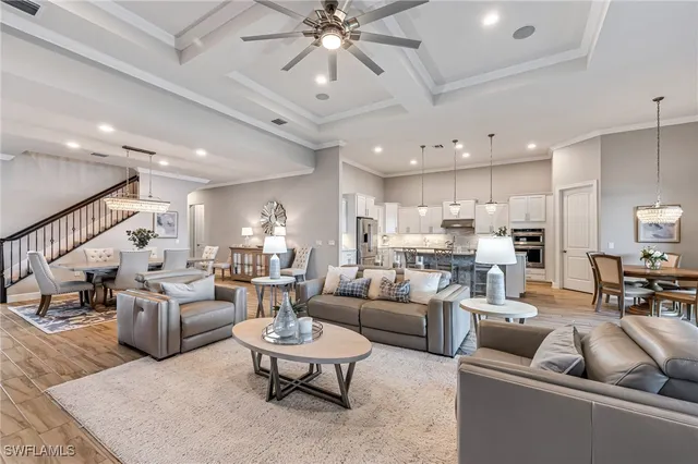 a living room with furniture kitchen view and a chandelier