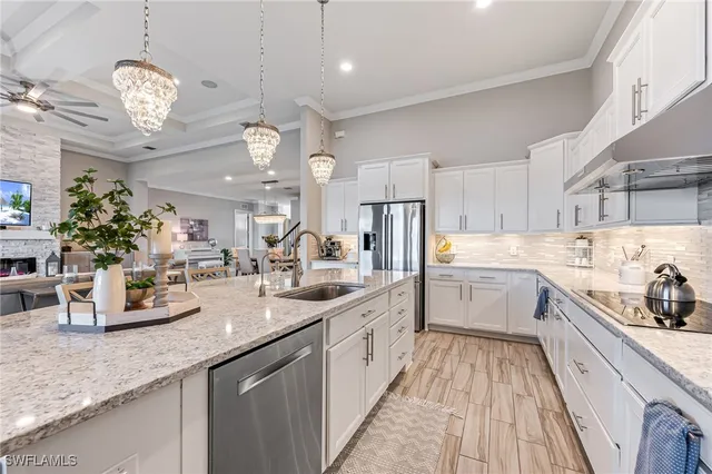 a large white kitchen with a large counter space a sink and cabinets