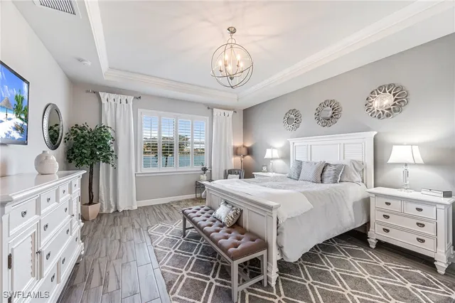 a bedroom with a bed and a chandelier