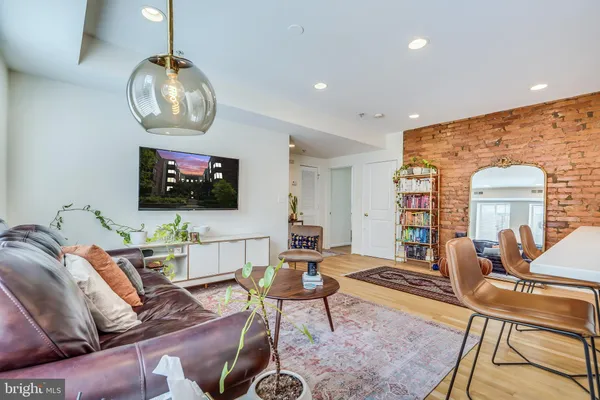 a living room with furniture a flat screen tv and kitchen view