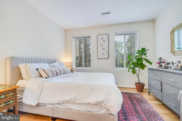 a bedroom with a large bed and a potted plant