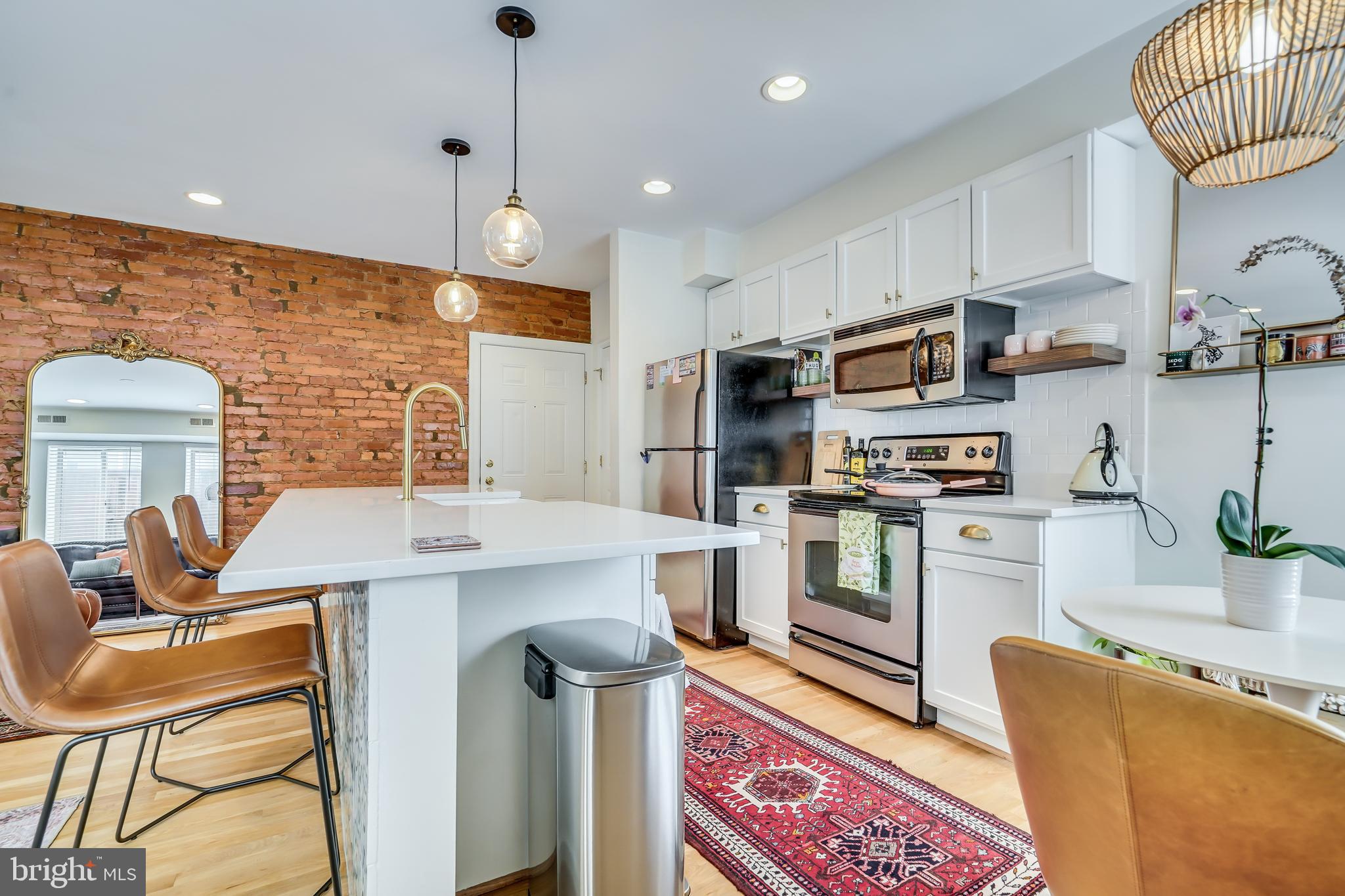 5405 9th Street Northwest, Unit 106 Washington, DC 20011 - Photo 7 of 21 a kitchen with stainless steel appliances kitchen island granite countertop a sink a stove a refrigerator cabinets and chairs