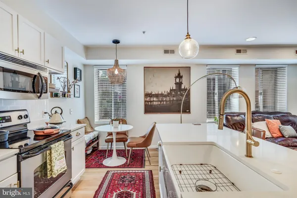 a living room with furniture a flat screen tv and kitchen view