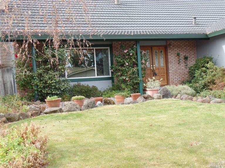 a view of a house with backyard and sitting area
