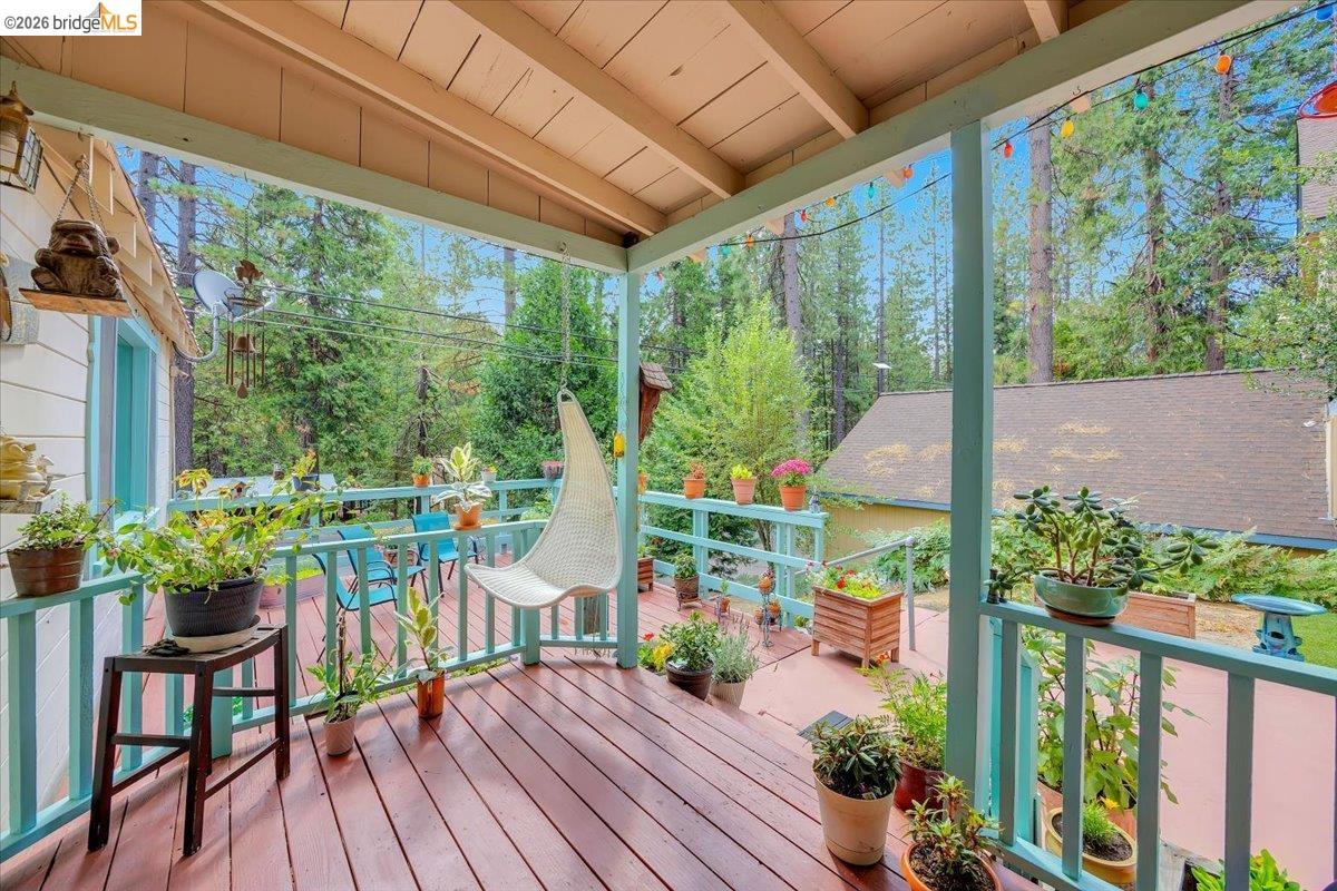 26144 Long Barn Road Long Barn, CA 95335 - Photo 29 of 42 Covered porch with wood-finish decking, light blue railings, and a wood ceiling