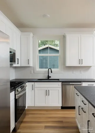 a kitchen with stainless steel appliances granite countertop a sink and a stove