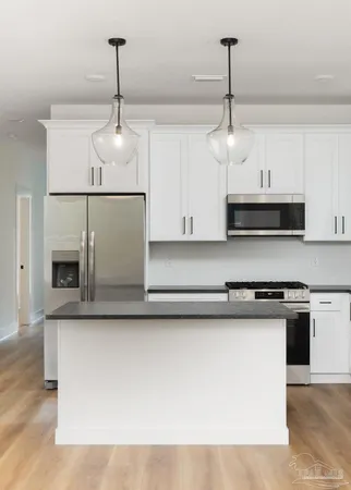 a kitchen with stainless steel appliances granite countertop a sink a stove and a microwave