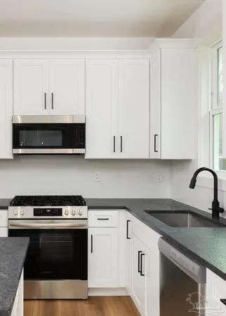 a kitchen with granite countertop a stove and a sink