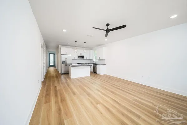 a view of a kitchen with wooden floor and electronic appliances