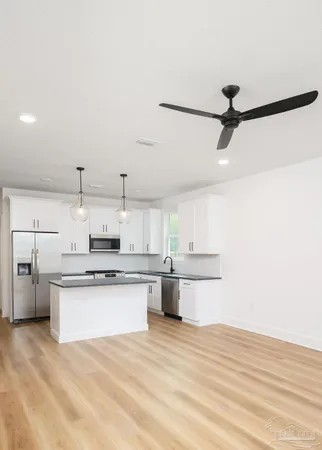 a kitchen with stainless steel appliances a stove refrigerator and cabinets