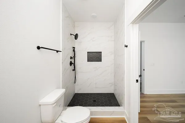 a bathroom with a toilet and a shower