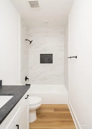 a bathroom with a granite countertop sink toilet and shower