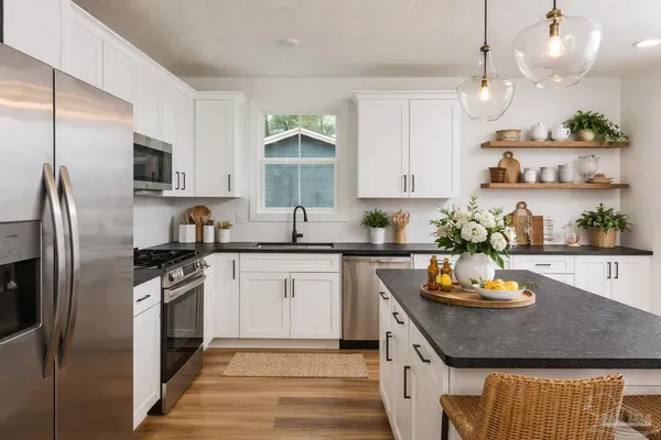 a kitchen with stainless steel appliances granite countertop a sink a stove and refrigerator