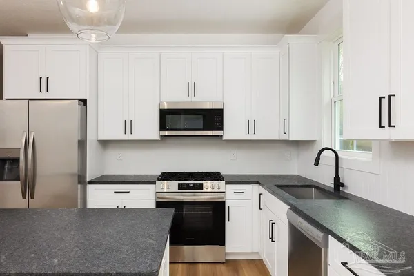 a kitchen with a sink a stove and refrigerator