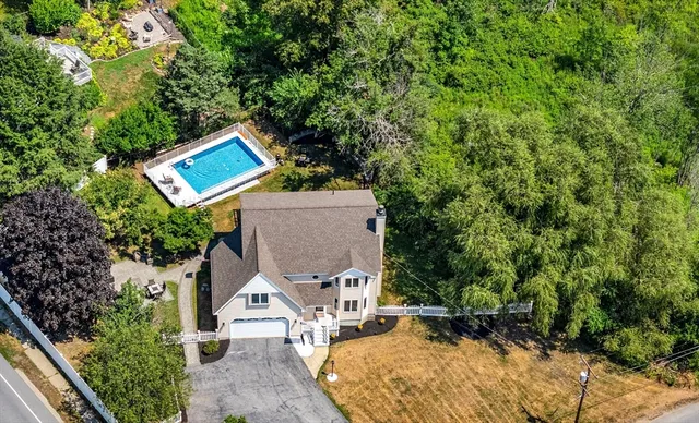 an aerial view of a house with swimming pool and garden